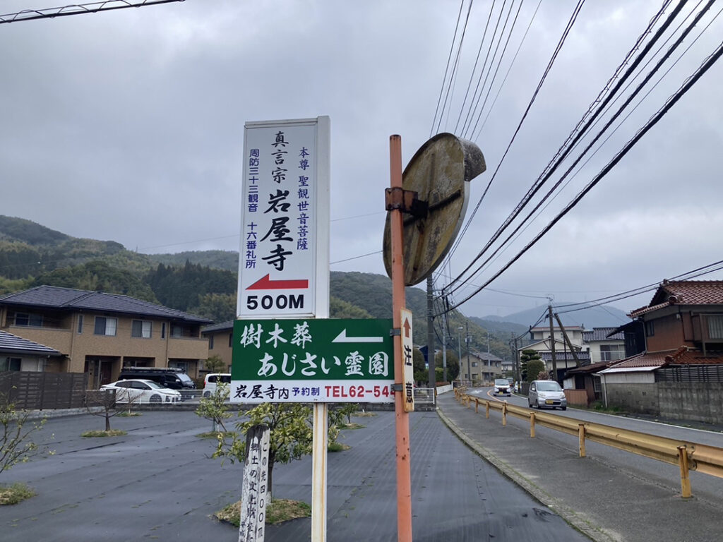 道路脇の案内看板。岩屋寺500Mと、樹木葬あじさい霊園の矢印